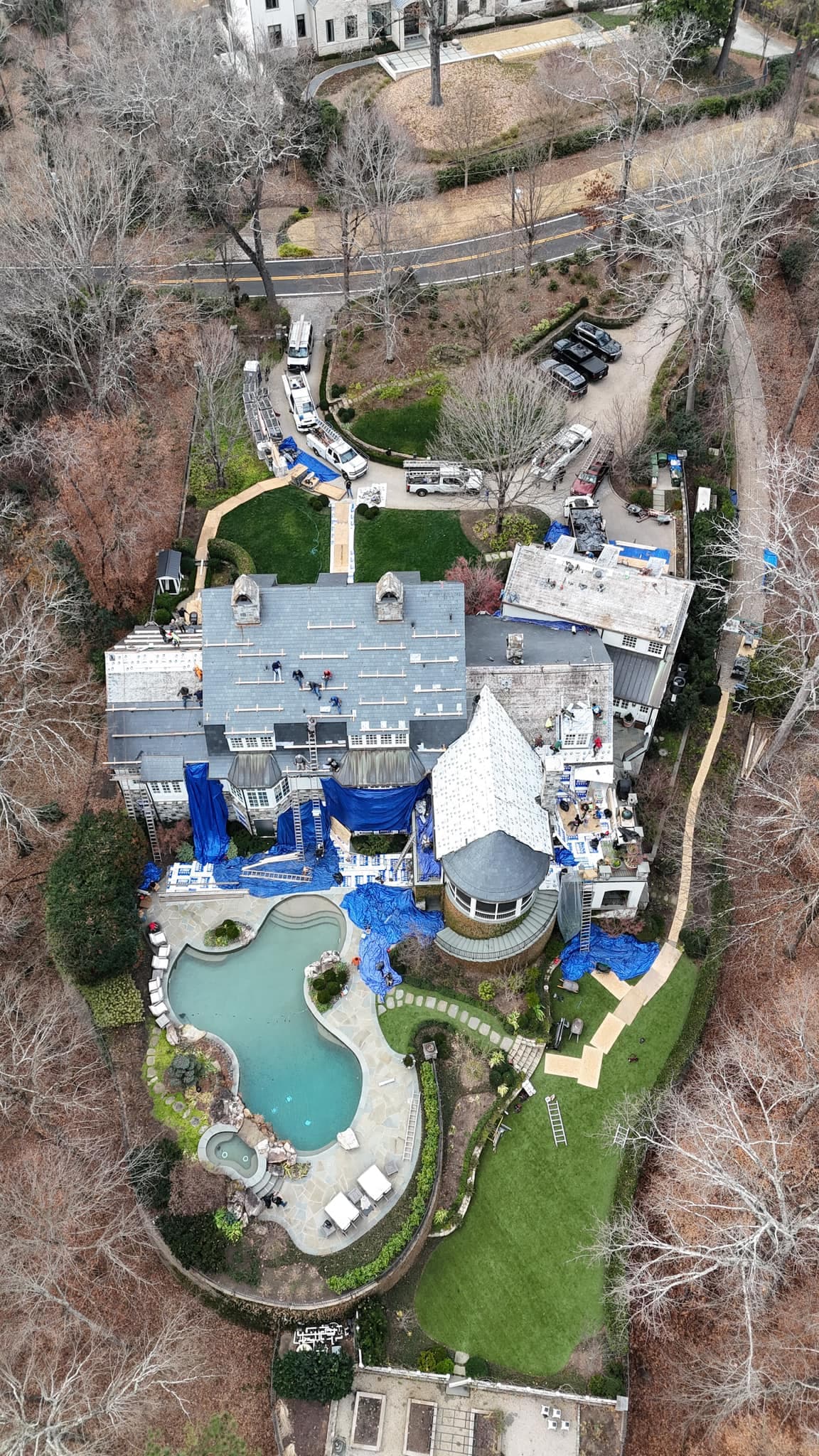 The same property mid-construction in winter, scaffolding and tarps in place