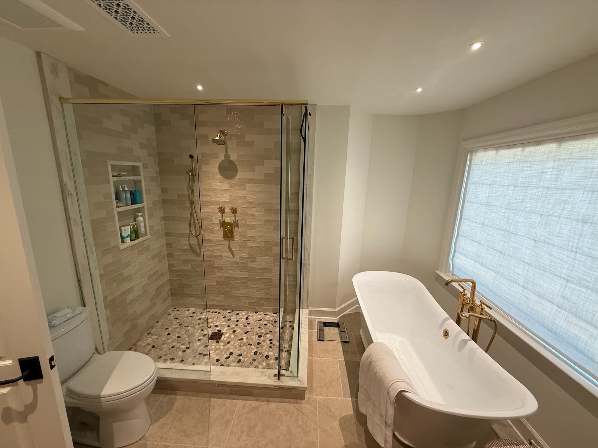 Spa-style ensuite with brass fittings and freestanding tub