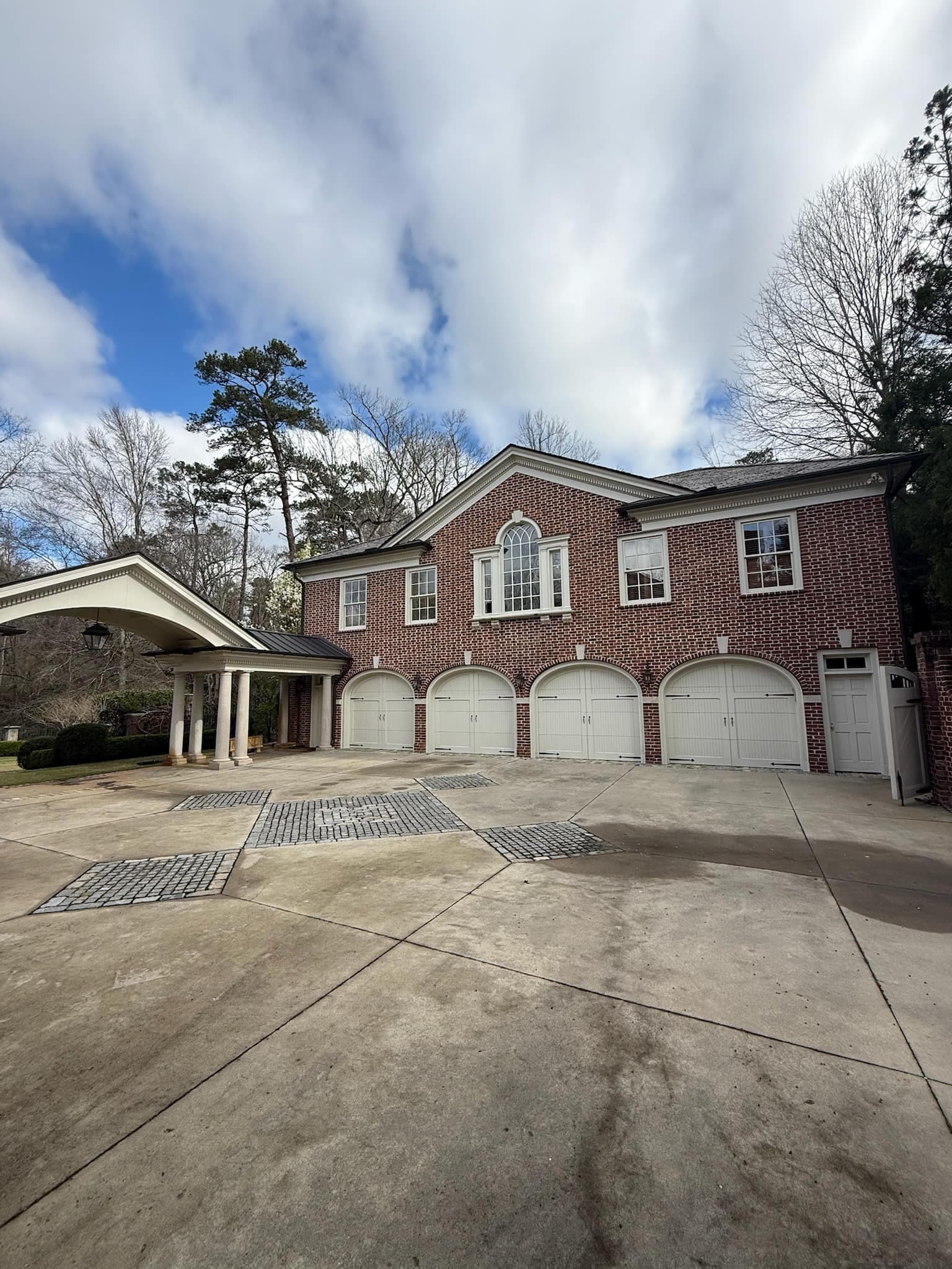 Brick estate exterior with arched garage bays and porte-cochere